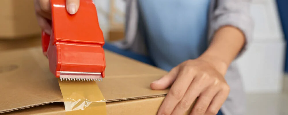 woman-packing-box-with-tape